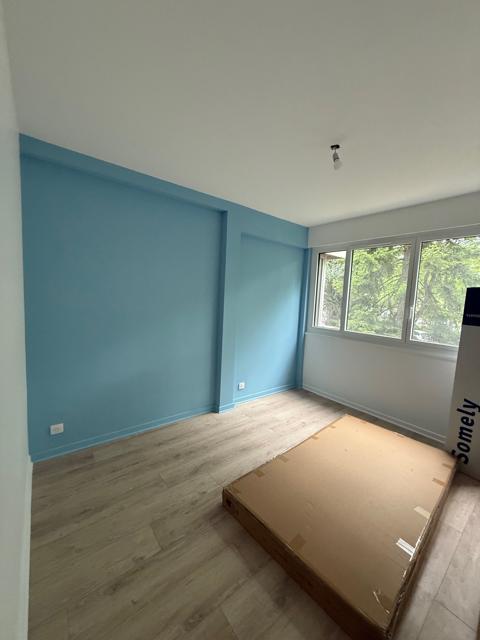 Chambre avec mur bleu et estrade en bois