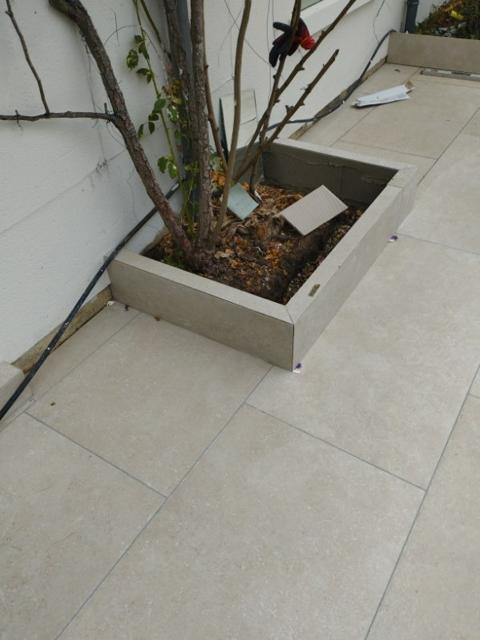 Cour carrelée avec jardinière
