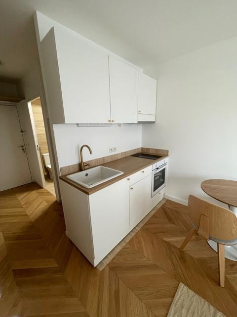 Kitchenette blanche, plan de travail bois et robinet laiton