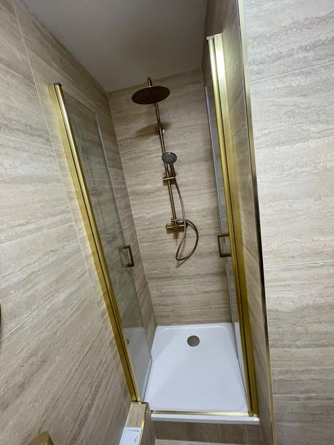 Douche à paroi vitrée et finitions laiton