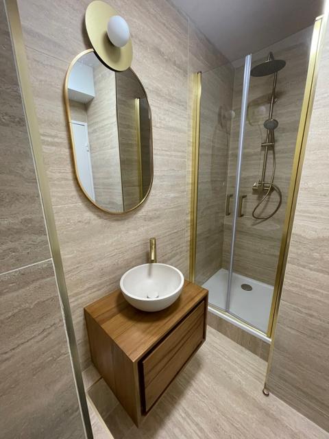 Salle d’eau avec vasque, miroir et douche